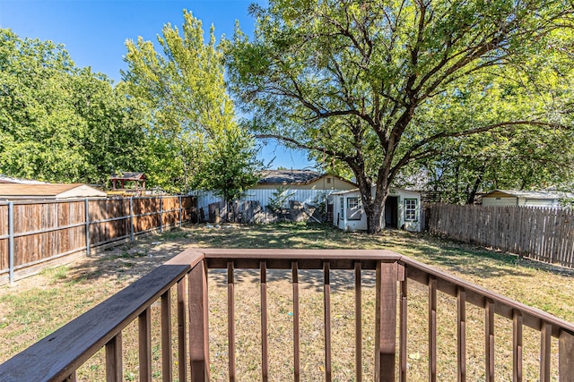 view of yard featuring a deck and a storage unit