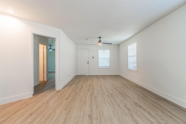 unfurnished living room featuring ceiling fan and light wood-type flooring