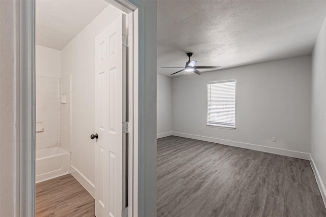 interior space with dark wood-type flooring, a textured ceiling, and ceiling fan