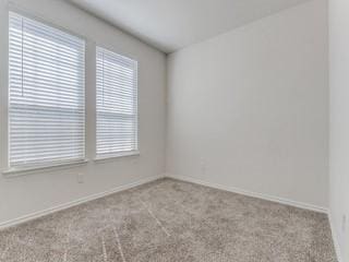 unfurnished room with light carpet and baseboards