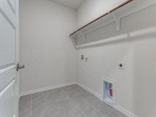 laundry area with laundry area, visible vents, baseboards, and electric dryer hookup