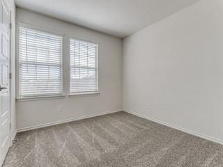 unfurnished room with baseboards and light colored carpet