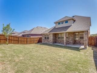 back of house with a fenced backyard, a yard, and a patio