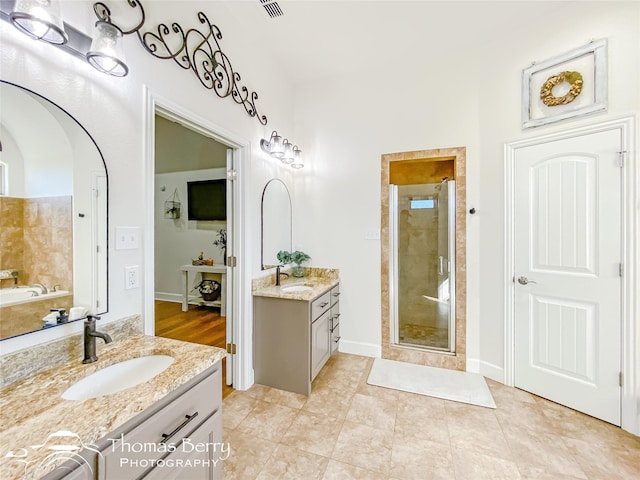 bathroom with walk in shower, vanity, and tile patterned flooring