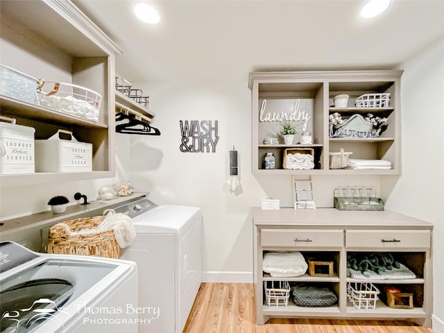 clothes washing area featuring light hardwood / wood-style floors and washer and dryer