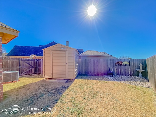 view of yard with central AC and a storage shed