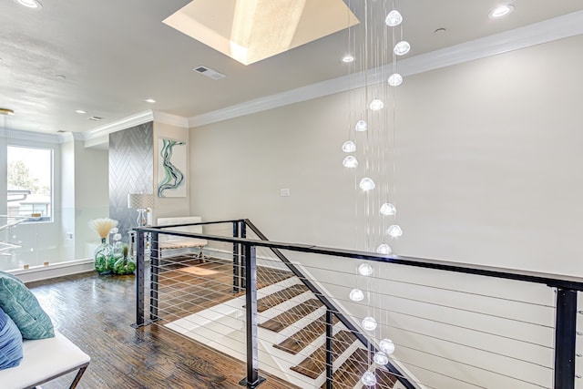 stairway featuring crown molding and hardwood / wood-style floors