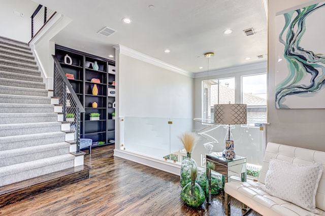 living area featuring wood-type flooring and ornamental molding