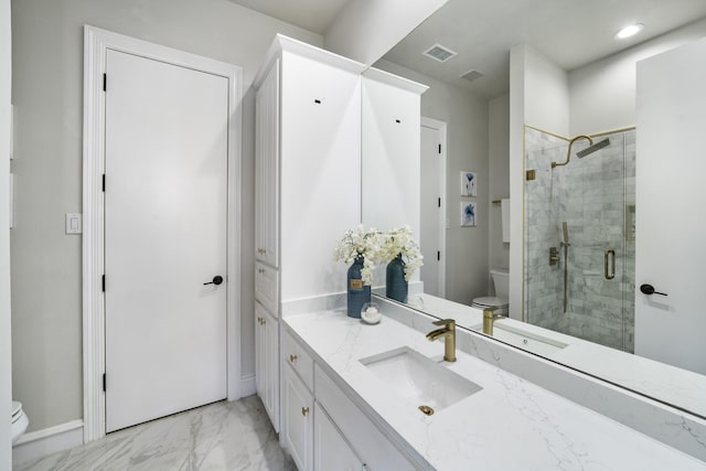 bathroom featuring a shower with door, vanity, and toilet