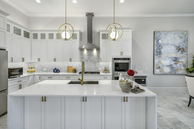 kitchen with appliances with stainless steel finishes, decorative light fixtures, wall chimney range hood, a kitchen island with sink, and light stone counters