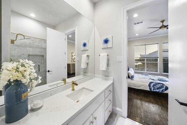 bathroom featuring crown molding, wood-type flooring, an enclosed shower, ceiling fan, and vanity