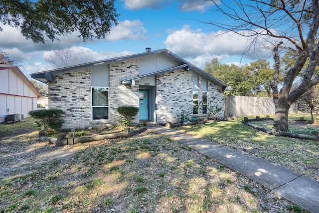 view of front of home with central AC unit and a front yard