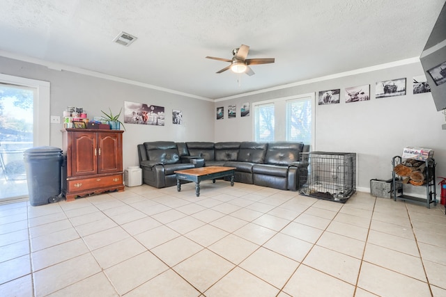 living room featuring ceiling fan, ornamental molding, a textured ceiling, and light tile patterned floors