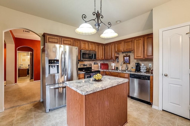 kitchen with a kitchen island, decorative light fixtures, sink, backsplash, and stainless steel appliances