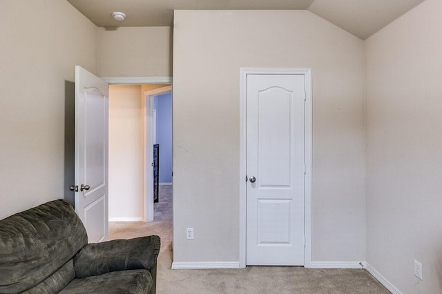 sitting room with lofted ceiling and light colored carpet