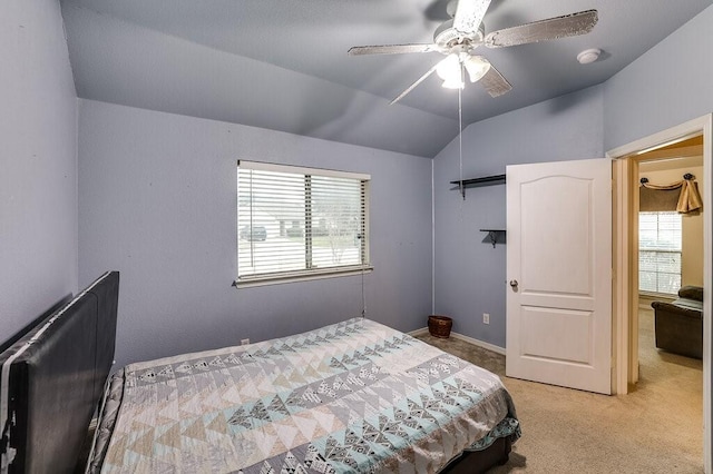 carpeted bedroom featuring multiple windows, vaulted ceiling, and ceiling fan