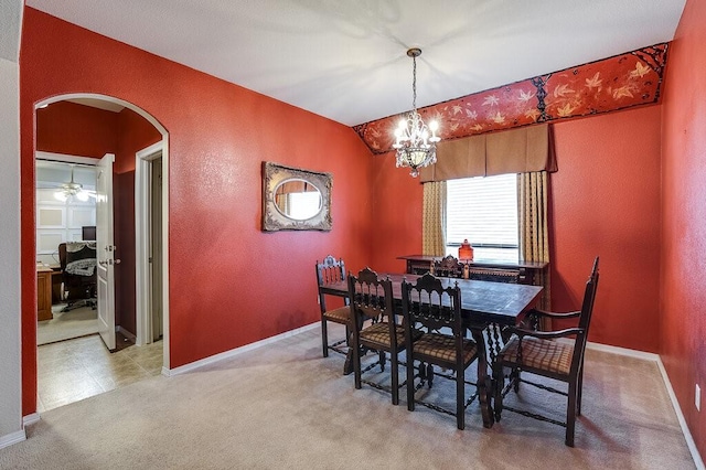 carpeted dining area with a chandelier