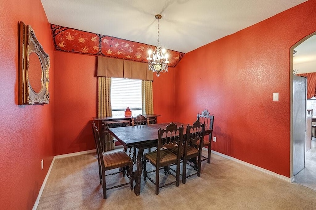 carpeted dining space with an inviting chandelier