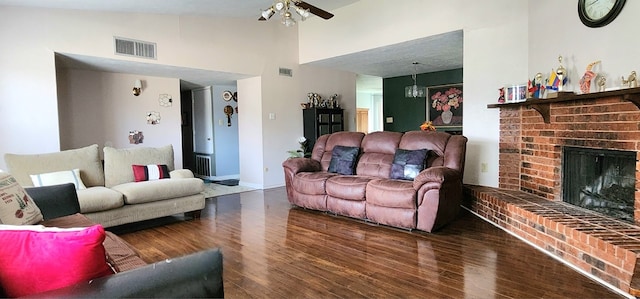 living room featuring vaulted ceiling, ceiling fan, a fireplace, and dark hardwood / wood-style flooring