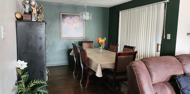 dining room featuring a chandelier and dark wood-type flooring