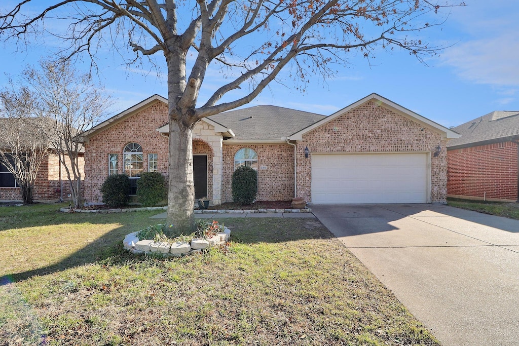 ranch-style home with a garage and a front yard