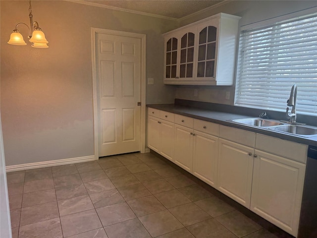 kitchen featuring dishwasher, sink, white cabinets, hanging light fixtures, and crown molding