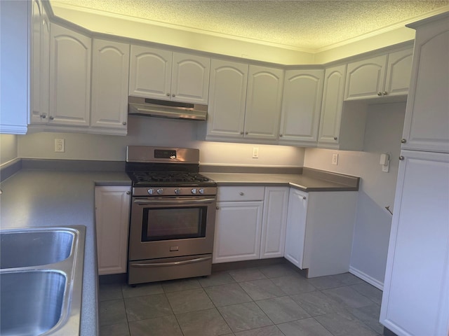 kitchen with sink, stainless steel gas range, white cabinetry, tile patterned flooring, and a textured ceiling