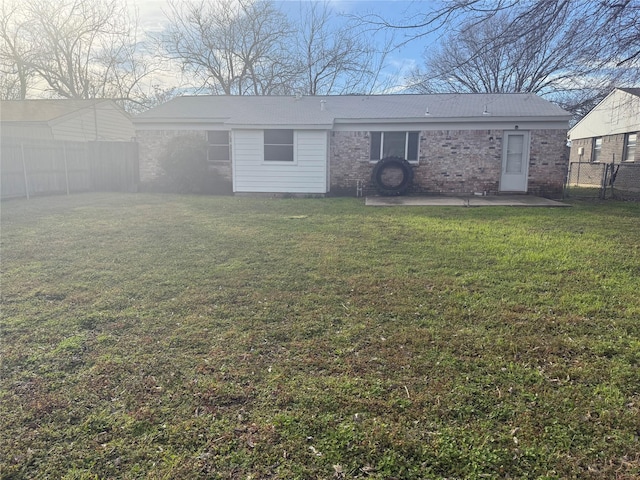 rear view of property featuring a yard and a patio area