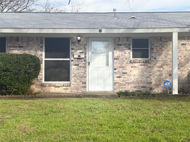 doorway to property with a lawn