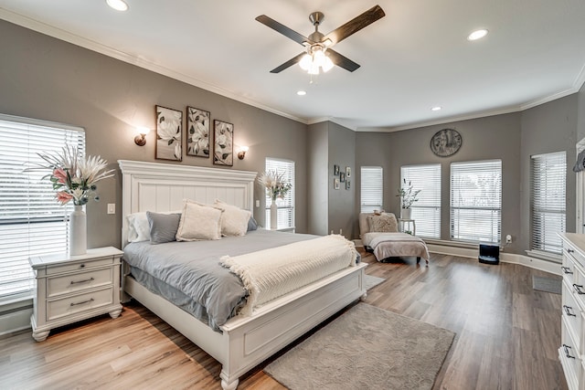 bedroom featuring crown molding, light hardwood / wood-style flooring, and ceiling fan