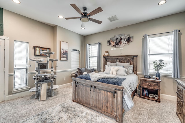 carpeted bedroom featuring multiple windows and ceiling fan