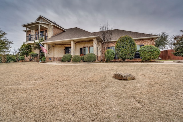 view of front of house with a front yard and a balcony