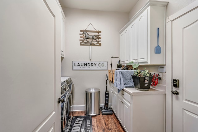 laundry area with dark wood-style flooring, baseboards, cabinet space, and washer and clothes dryer