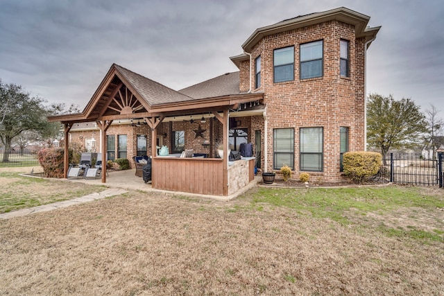 back of property with a ceiling fan, a patio area, fence, and brick siding