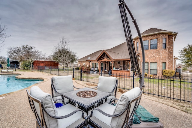 view of patio / terrace with fence, a fenced in pool, and a fire pit