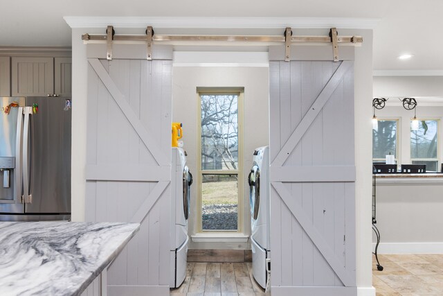 laundry room with ornamental molding, washer / clothes dryer, and a barn door