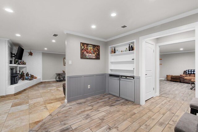 interior space with built in shelves, gray cabinets, and ornamental molding