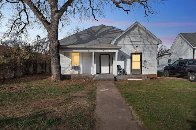 view of front of house with cooling unit and a lawn