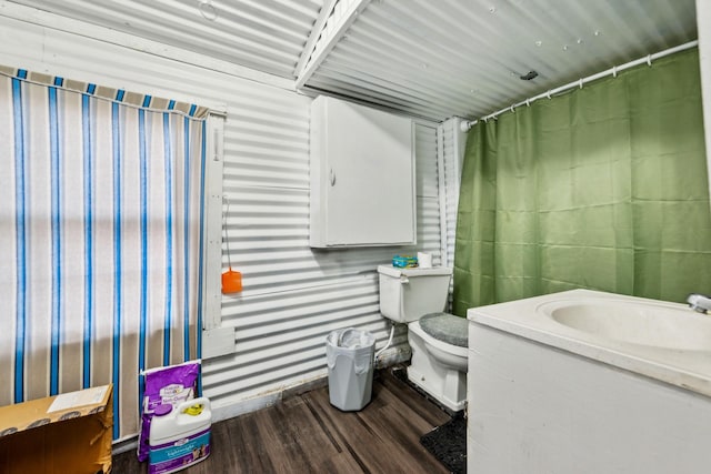 bathroom with hardwood / wood-style floors, toilet, and vanity