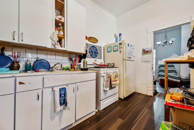 kitchen with white appliances, white cabinets, decorative backsplash, dark hardwood / wood-style floors, and a chandelier