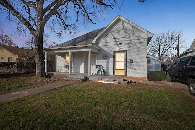 view of front of property featuring covered porch and a yard