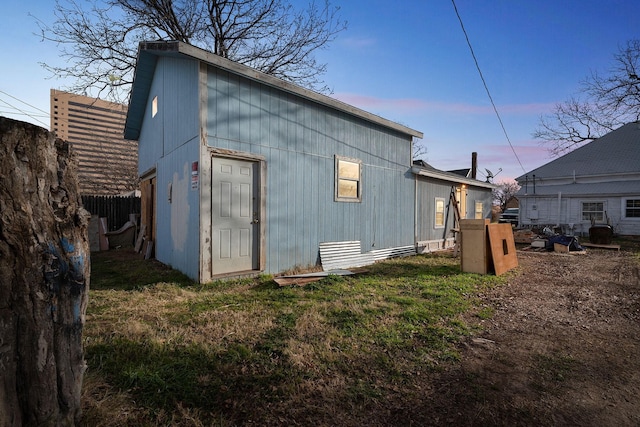 outdoor structure at dusk featuring a yard