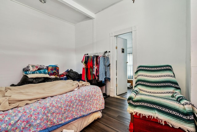 bedroom with dark wood-type flooring and beamed ceiling