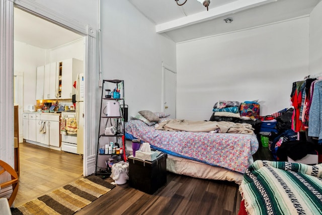 bedroom with vaulted ceiling with beams and light hardwood / wood-style flooring