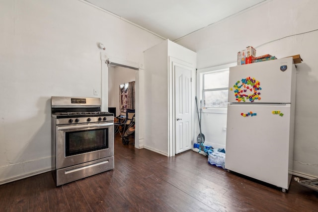 kitchen with stainless steel range with gas cooktop, dark hardwood / wood-style floors, and white refrigerator