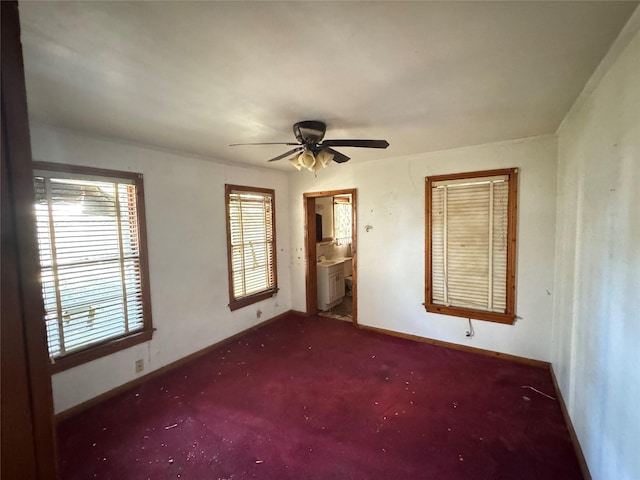 unfurnished bedroom with ceiling fan, connected bathroom, radiator, and dark colored carpet