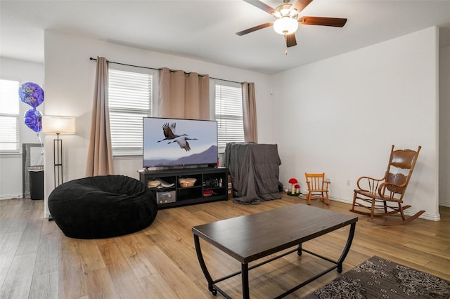 living area with ceiling fan and light hardwood / wood-style flooring