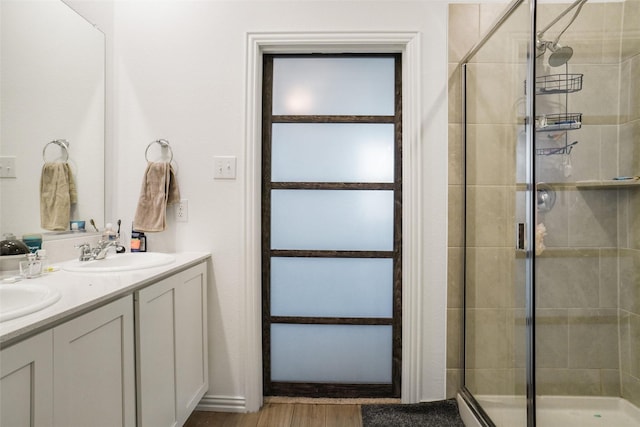 bathroom featuring wood-type flooring, a shower with door, and vanity