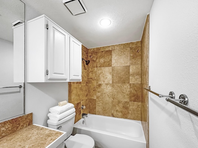 full bathroom featuring a textured ceiling, toilet, vanity, and tiled shower / bath combo