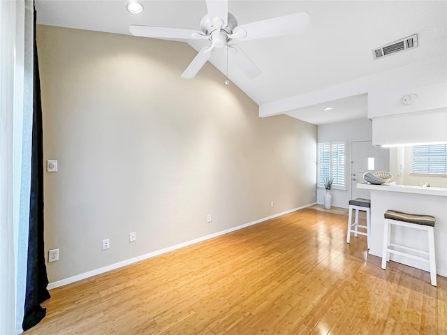 unfurnished living room featuring vaulted ceiling, ceiling fan, and light wood-type flooring